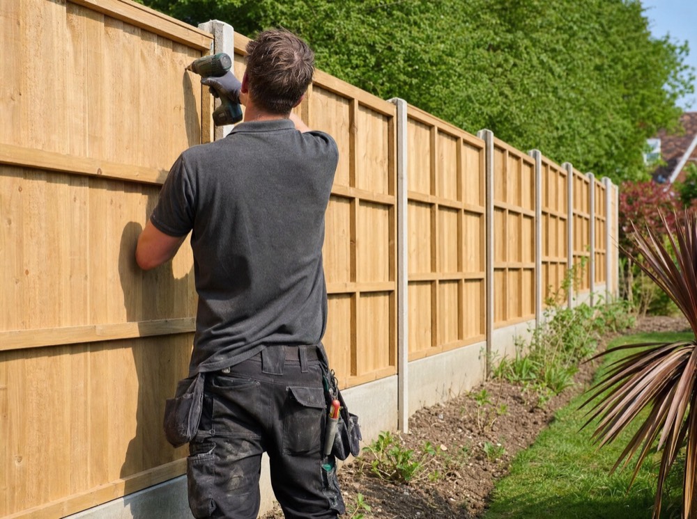 Fencing contractor fitting a new panel